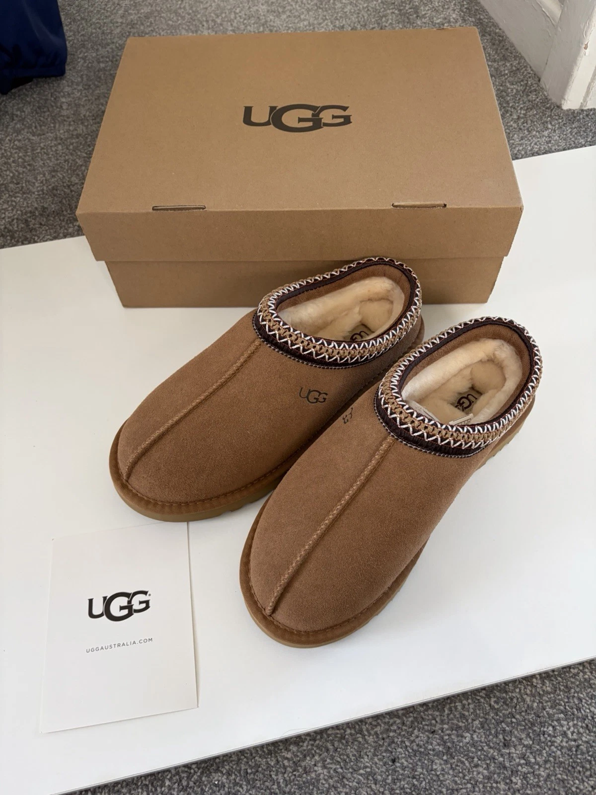 Chestnut UGG Tasmans with their box and info card