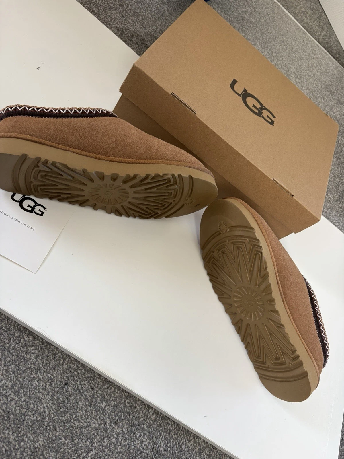 The soles of the UGG Tasmans, next to the UGG box